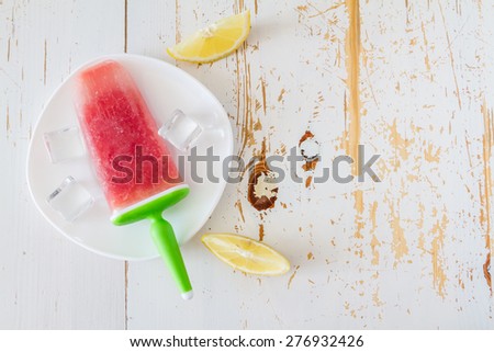 Watermelon fruit ice pops on white plate, white wood background