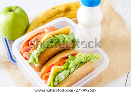 Lunch box for school - sandwiches, milk, apple, banana, white wood background, closeup