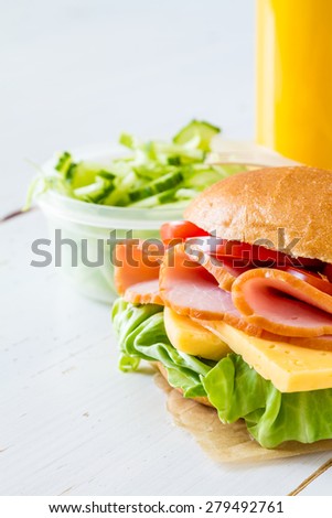 Lunch box for school - sandwich, juice, salad, white wood background