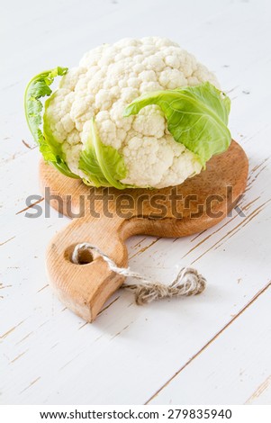 Cauliflower on wood board, white wood background