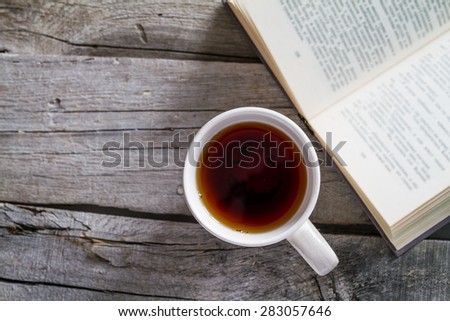 Morning snack - book, tea, on rustic wood background, top view