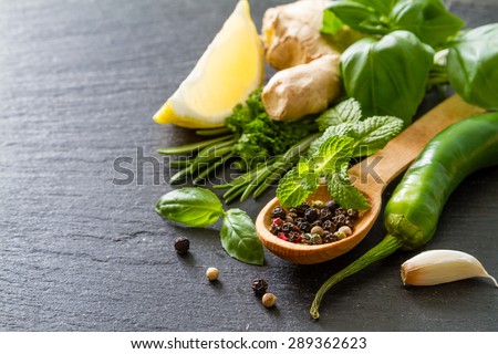 Herbs background - chili, lemon, mint, parsley, basil, garlic, ginger, rosemary,  dark stone background