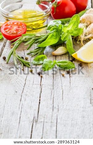 Herbs background - rosemary, basil, mint, ginger, lemon, tomatoes, oil, chili, garlic, pepper, rustic wood background, closeup