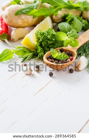 Herbs background - chili, lemon, mint, parsley, basil, garlic, ginger, rosemary,  white wood background
