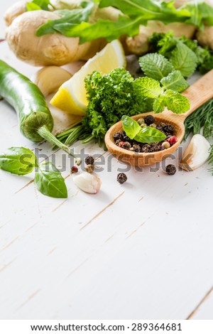 Herbs background - chili, lemon, mint, parsley, basil, garlic, ginger, rosemary,  white wood background