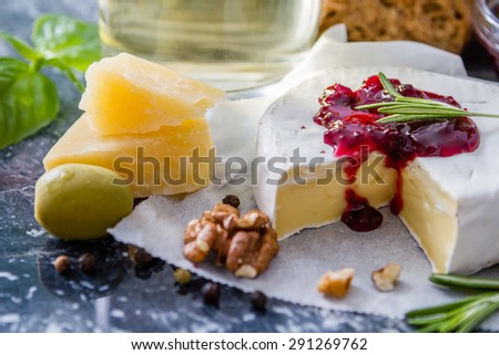 Appetizer - cheese, baguette, ham, nuts, olive, basil, wine, marble board