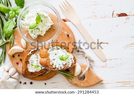 Garlic bread - baguette slices, garlic butter, herbs, wood board, white wood background, top view