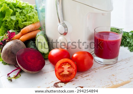 Violet vegetable juice, cucumber, lemon, spinach, tomatoes, beet, carrot, white wood background