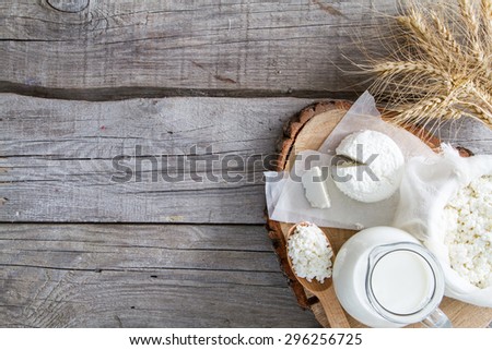 Fresh dairy products (milk, cottage cheese), wheat, rustic wood background, top view