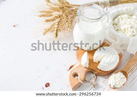 Fresh dairy products (milk, cottage cheese), wheat, white wood background, top view