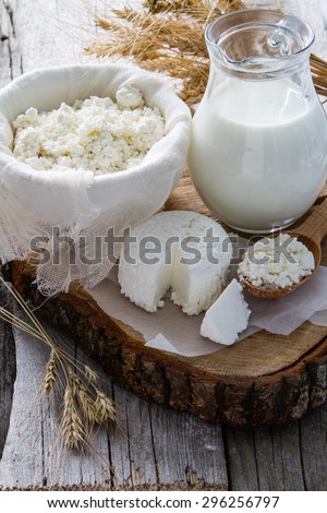 Fresh dairy products (milk, cottage cheese), wheat, rustic wood background