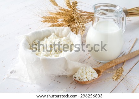Fresh dairy products (milk, cottage cheese), wheat, white wood background