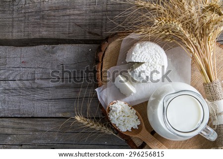 Fresh dairy products (milk, cottage cheese), wheat, rustic wood background, top view