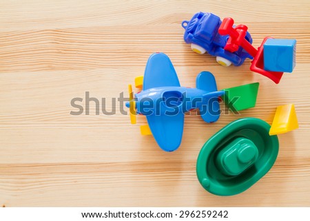 Transport infrastructure concept - toy ship, truck and plane, wood background, top view