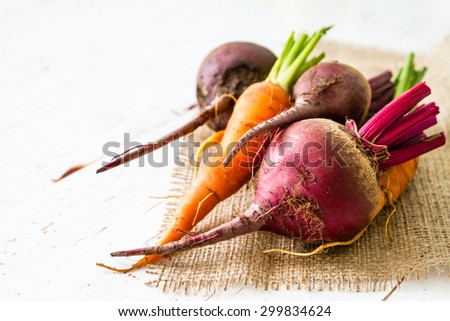 Raw beet and carrot, white wood background
