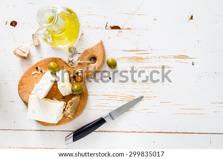 Feta, olives, oil, white wood background, top view