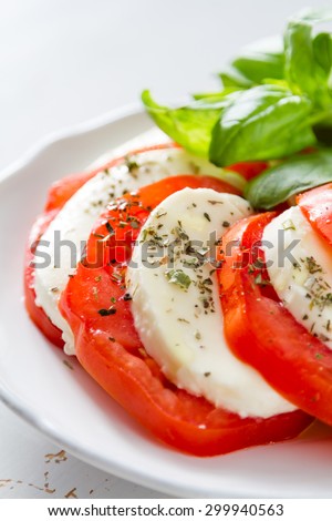 Insalata caprese - tomato, mozzarella, basil, olive oil, white , white wood background