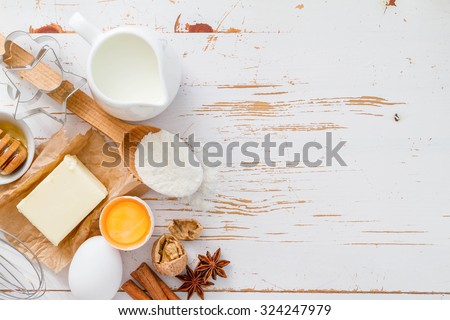 Ingredients for baking - milk butter eggs flour wheat, white wood background, copy space, top view