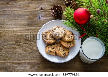 Cookies and milk for Santa Clause on wood background, copy space