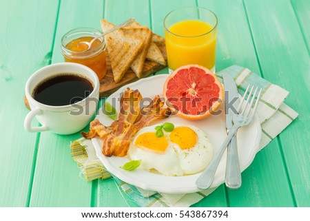 Summer breakfast - eggs, bacon, toast, jam coffee juice copy space