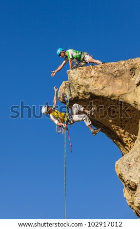 Climbing team struggle to the summit of a challenging rock mountain.