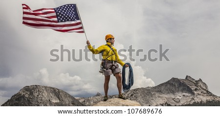 Climber waves an American Flag from the summit after a challenging ascent.