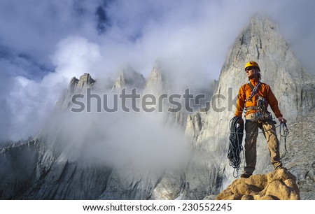 Climber on the summit of a challenging cliff.