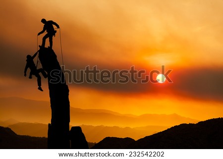 Climbers on the summit of a challenging cliff.