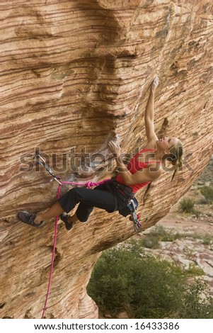 Young woman rock climbing in The Calico Hills, in Red Rock, Nevada.