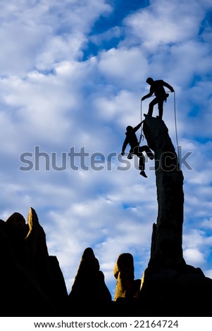 Team of climbers reaching the summit of a rock pinnacle in The Sierra Nevada Mountains, California.