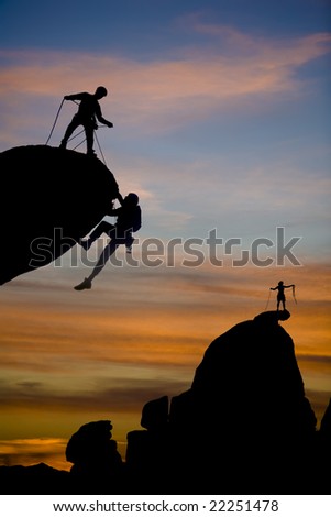 Team of climbers reaching the summit of a rock pinnacle in The Sierra Nevada Mountains, California.