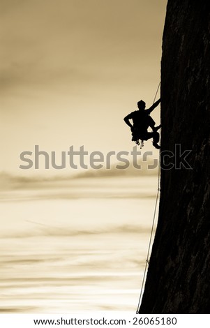 A climber is silhouetted as he clings to a steep rock face in Joshua Tree National Park, California.