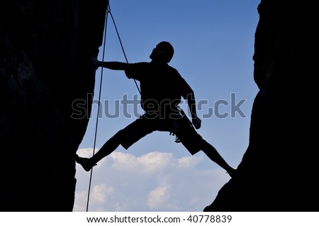 A rock climber is silhouetted as he climbs up a chimney in Sequoia National Park, California, on a summer day.