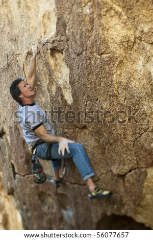 Rock climber ascending an overhanging rock face in Joshua Tree National Park.