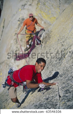 Team of climbers struggle up a steep crack.