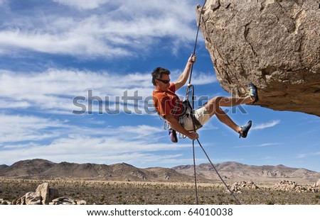 A climber rappelling from the summit of a rock spire after a successful ascent in The Sierra Nevada Mountains, California.