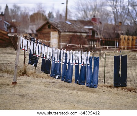 Freshly washed socks and pants hanging out to dry on a clothesline.