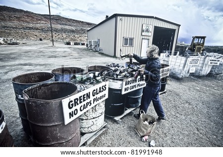 Young woman separates glass and plastic at the recycle center.