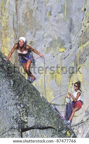Team of female climbers struggle for their next grip on a challenging ascent.