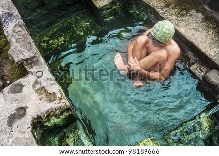 Woman soaking in a rustic, natural hotpool on the East Side of the Sierra Nevada mountains.