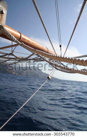 Sailboat in action, big white sail raised over blue clear sky