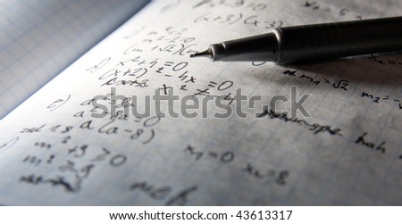 A pen with page of maths notebook in background- dramatic lightening