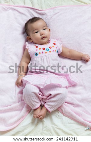 Cute Asian baby girl lay down on blanket sheet