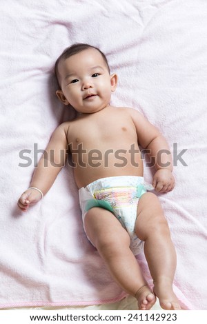 Cute Asian baby girl in Diaper lay down on blanket sheet
