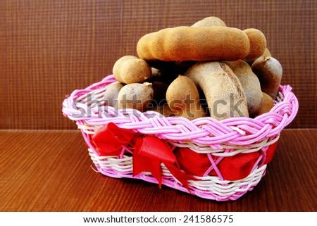tamarinds are  in the pink basket on wooden background