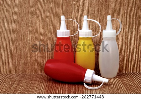 small sauce bottle on wooden background in dry paint