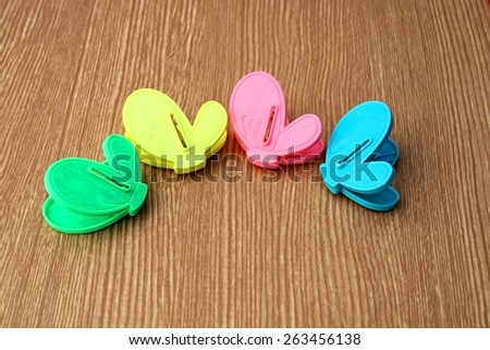 Four of plastic color clip are on the wooden background in dry paint