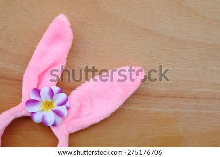 pink bunny hair band with purple flower on wooden background