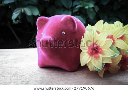 close up image of piggy bank and flower in vintage tone