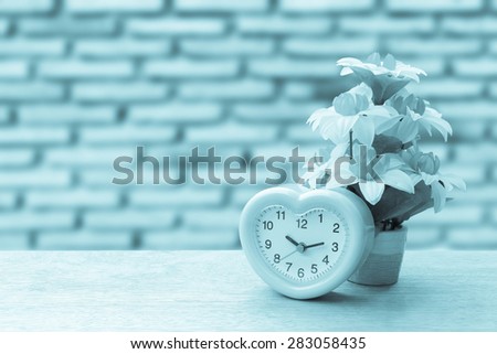 pink clock and flower vase on blur old dirty brick wall background